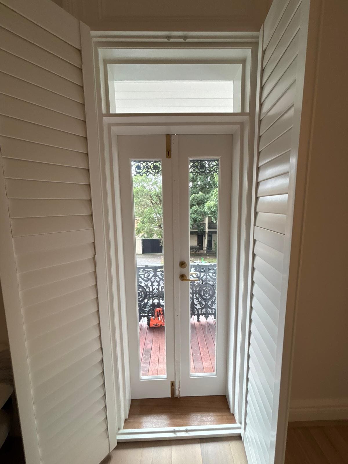 Restored French doors opening to a balcony with iron balustrade in Balmain