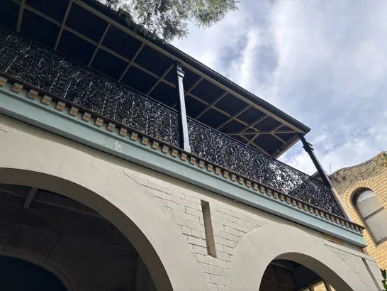 Ornate wrought-iron balcony lacework on a heritage facade