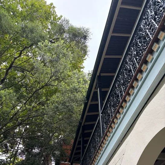 Low-angle view of a heritage verandah with ornate wrought-iron lacework