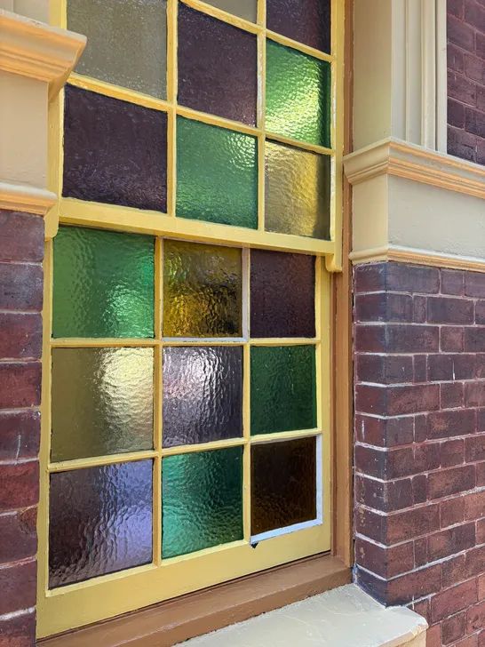 Heritage coloured glass window with purple, green, and amber panes